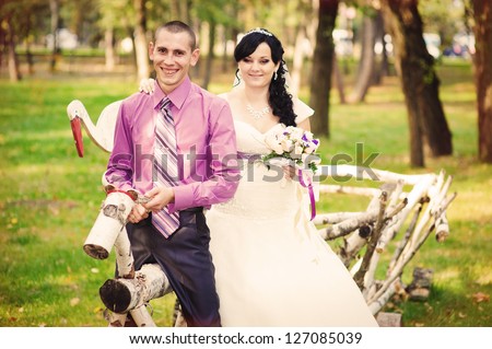 The groom and the bride in a vehicle. Groom and Bride in a park. wedding dress. Bridal wedding bouquet of flowers