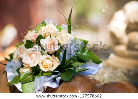 wedding bouquet of the bride and yellow roses lies on the edge of the fountain with the water splashing