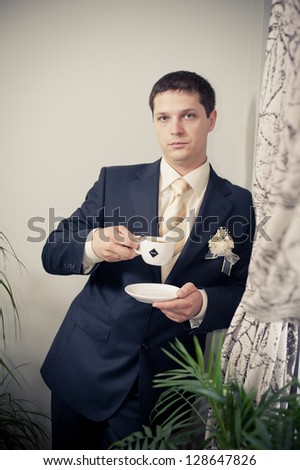 Happy young groom on his wedding day. Handsome caucasian man in tuxedo. A young, handsome guy, dark hair in a black suit. Portrait