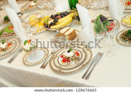 fresh salads and sausages on holiday table in wedding day. fruit in a vase on the holiday table