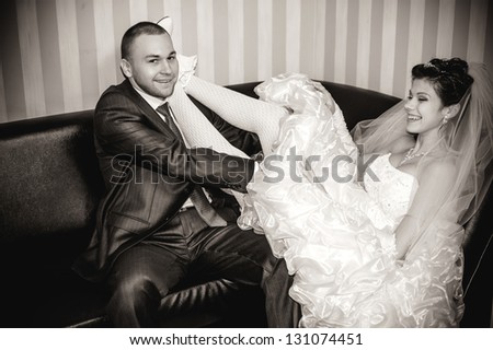 wedding couple hugging, bride and groom on a sofa, the groom embracing her