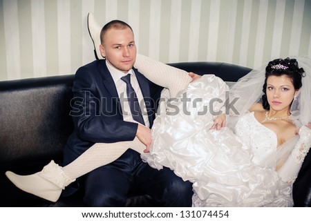 wedding couple hugging, bride and groom on a sofa, the groom embracing her
