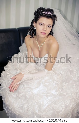 Beautiful bride in vintage royal interior. Beautiful luxurious woman model  sitting on a vintage couch. Wedding.