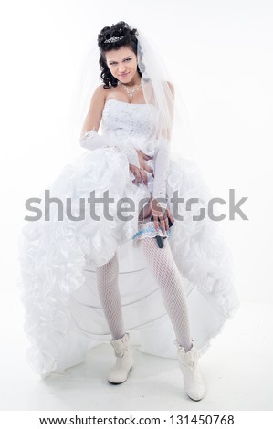 Young woman in a wedding dress with gun on a white background. bride. wedding. studio.