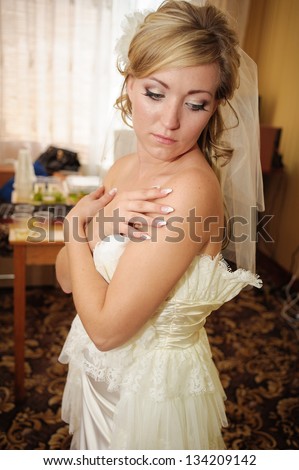Bride dressing gown. bride preparing for a wedding. bride is getting dressed in the room. brunette young bride prepare for the event