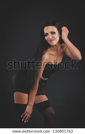 beautiful woman in sexy evening dress against dark background. Portrait of glamour beautiful young woman. portrait of sexy woman posing in black lingerie over black background
