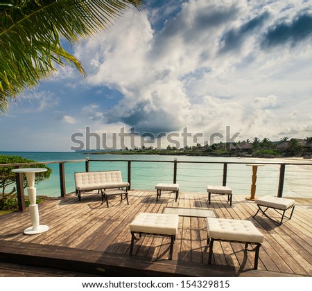Outdoor restaurant at the beach. Cafe on the beach, ocean and sky. Table setting at tropical beach restaurant. Dominican Republic, Seychelles, Caribbean, Bahamas. Relaxing on remote Paradise beach.