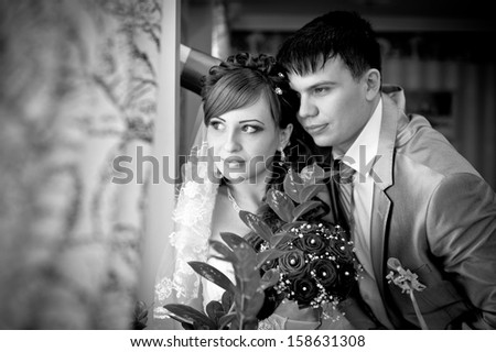 Cute married couple in cafe, groom kissing a bride. Pure tenderness. Bride and groom drinking coffee at an outdoor cafe. a romantic rest in vintage cafe interior. Bridal wedding bouquet of flowers.