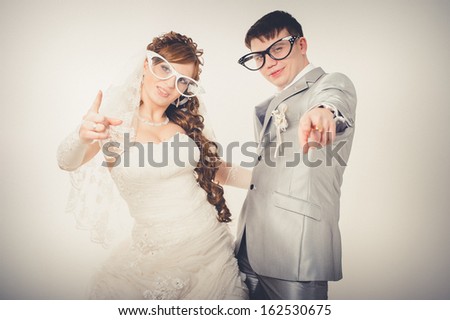 wedding theme, the bride and groom in funny glasses isolated on white background. Happy young newlyweds on wedding day. Wedding couple. wedding dress. Bridal wedding bouquet of flowers.
