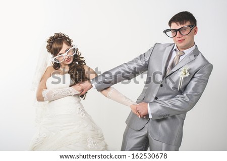 wedding theme, the bride and groom in funny glasses isolated on white background. Happy young newlyweds on wedding day. Wedding couple. wedding dress. Bridal wedding bouquet of flowers.