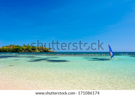 Surfer in the sea. Windsurfing Recreation. Alone surfer on board in sea with clear blue sky.