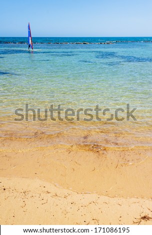 Surfer in the sea. Windsurfing Recreation. Alone surfer on board in sea with clear blue sky.