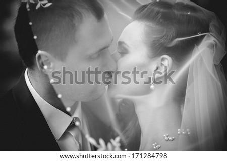 European bride and groom kissing in the park. Wedding shot of elegant bride and groom posing together outdoors on a wedding day. wedding dress. Bridal wedding bouquet of flowers.