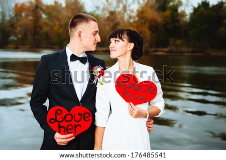 Wedding on the nature. couple in love bride and groom with a bouquet at bridal day in summer. Enjoy a moment of happiness and love and having fun Bride and groom outdoor portrait with red heart.