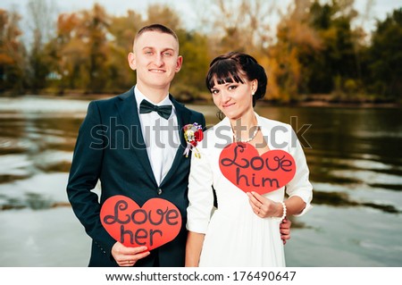 Wedding on the nature. couple in love bride and groom with a bouquet at bridal day in summer. Enjoy a moment of happiness and love and having fun Bride and groom outdoor portrait with red heart.