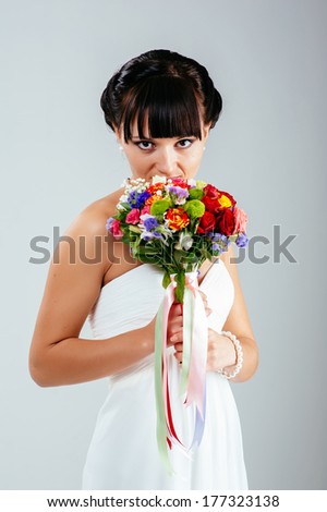 Wedding. Young attractive bride with the bouquet of wildflowers. Isolated on white background. Happy holiday of new family. Wedding bouquet of flowers and bridal dress