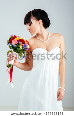 Wedding. Young attractive bride with the bouquet of wildflowers. Isolated on white background. Happy holiday of new family. Wedding bouquet of flowers and bridal dress