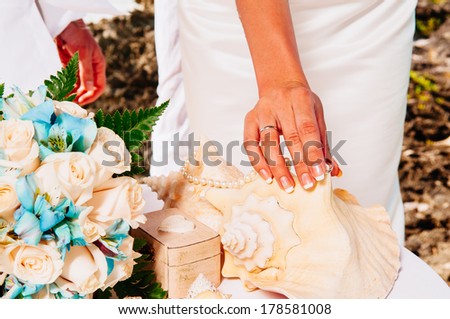 Newlyweds wear rings to each other on the background of the Caribbean. Groom put a ring on finger of his lovely wife. Wedding couple together. Closeup groom and bride hands in wedding ceremony
