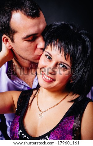beautiful young happy couple love smiling embracing, man and woman smile, isolated over black background. Man admits girl in love and proposes to marry him. Happy Valentine's Day!