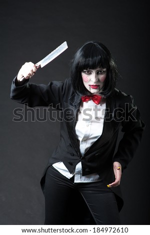 Scary portrait of an angry woman with a sharp knife bathed in the blood. one strange young woman killer holding bloody knife. Halloween. Criminal woman in vintage black coat with an ax in his hands