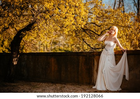 Beauty Girl Outdoors enjoying nature. Beautiful Teenage Model girl in white dress on the Spring Field, Sun Light. gorgeous bride enjoying walking in spring forest. Free Happy Woman. warm colors