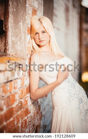 Beauty Girl Outdoors enjoying nature near the ancient castle. Beautiful Teenage Model girl in white dress on the Spring Field, Sun Light. gorgeous bride enjoying walking in spring forest. Happy Woman