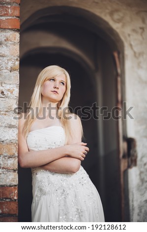Beauty Girl Outdoors enjoying nature near the ancient castle. Beautiful Teenage Model girl in white dress on the Spring Field, Sun Light. gorgeous bride enjoying walking in spring forest. Happy Woman