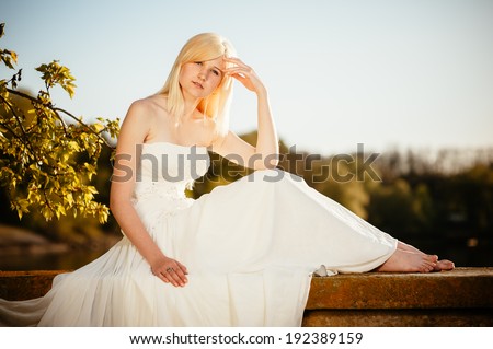 Beauty Girl Outdoors enjoying nature. Beautiful Teenage Model girl in white dress on the Spring Field, Sun Light. gorgeous bride enjoying walking in spring forest.  Free Happy Woman.