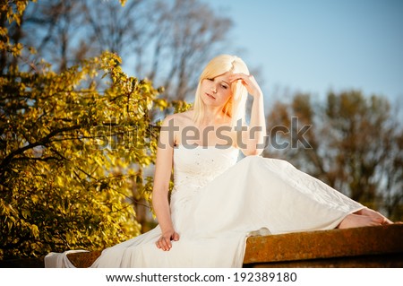 Beauty Girl Outdoors enjoying nature. Beautiful Teenage Model girl in white dress on the Spring Field, Sun Light. gorgeous bride enjoying walking in spring forest.  Free Happy Woman.