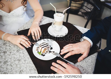bride and groom holding hands in a cafe. sensual happy married couple in restaurant. summer holidays, love, travel, tourism, relationship and dating concept - romantic happy couple kissing in the cafe