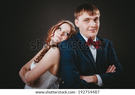 Loving bride and groom. newly-married couple on the isolated black background. Affectionate bride and groom with head to head.