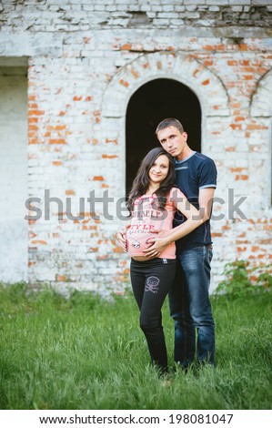 Portrait of beautiful loving couple awaiting baby. young happy family. Young family with a sun on the nature.