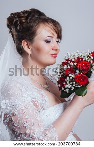 bride with bouquet of roses on a white background. Brunet bride portrait in studio