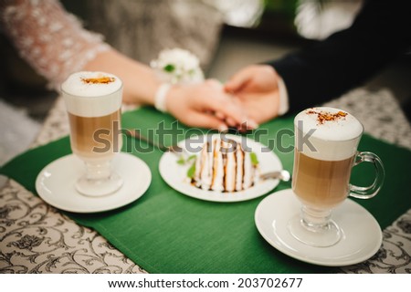 Cappuccino or latte coffee with heart shape. bride and groom drink a cup of Coffee latte on the date. Happy young bride and groom drink a cup of Coffee latte with heart design on their wedding day