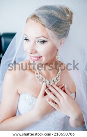 Portrait of beautiful woman in white dress. adorable bride is getting ready in the morning. Adorable young bride is getting ready in the morning at home.