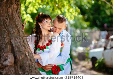 Ukraine. Happy Ukrainian wedding bridal couple in the ukrainian style. Beautiful bride and groom in the ukrainian style are standing with bouquet. Female and male models. Outdoor. park summer outdoor