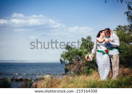 Ukraine. Happy ukrainian wedding (bridal) couple in the ukrainian style. Beautiful bride and groom in the ukrainian style are standing with bouquet. Female and male models.