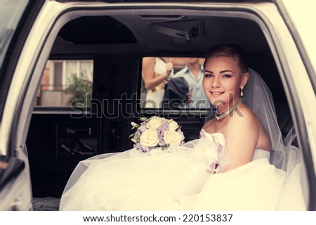 Portrait of a pretty bride in a car. closeup portrait of a pretty shy bride in a car window. bride in the car. wedding bouquet. cheerful face
