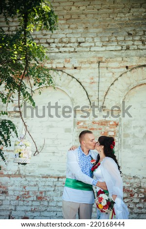 Ukraine. Happy ukrainian wedding (bridal) couple in the ukrainian style. Beautiful bride and groom in the ukrainian style are standing with bouquet. Female and male models.  park summer outdoor
