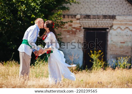 Ukraine. Happy ukrainian wedding (bridal) couple in the ukrainian style. Beautiful bride and groom in the ukrainian style are standing with bouquet. Female and male models.