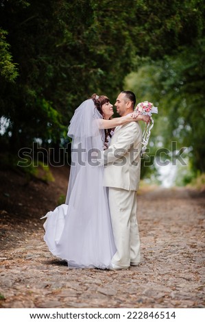Beautiful wedding couple is enjoying wedding. Groom and Bride in a park. wedding dress. Bridal wedding bouquet of flowers. Wedding shot of bride and groom in park
