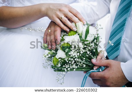 Wedding couple holding hands on bouquet. Groom and Bride in a park. wedding dress. Bridal wedding bouquet of flowers