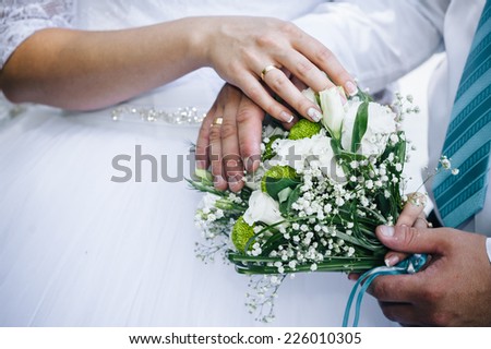 Wedding couple holding hands on bouquet. Groom and Bride in a park. wedding dress. Bridal wedding bouquet of flowers