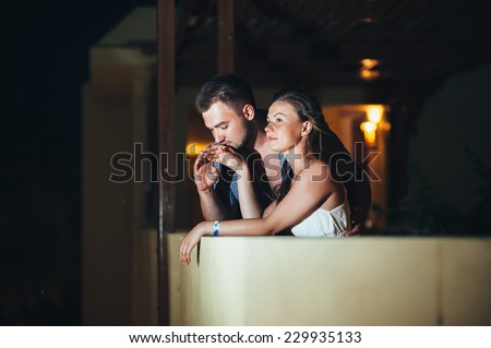 A couple in love standing on the stairs at night luxury hotel. Happy romantic couple on vacation