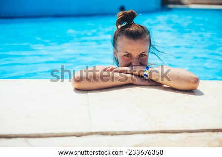 Sexy blonde woman in bikini posing in swimming pool. beautiful long hair female model posing by the pool, outdoor portrait