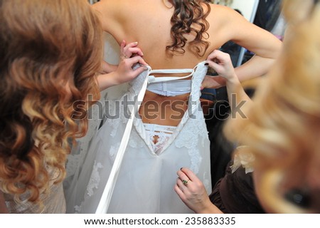 Bride getting ready. Bride dressing gown. bride is getting ready in the morning. Brides maid helps bride dress in wedding dress for wedding day