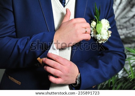 groom getting ready. A groom putting on cuff-links as he gets dressed in formal wear. Groom\'s suit.