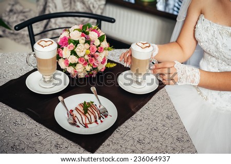 Hands of bride and groom. Cappuccino or latte coffee with heart shape. bride and groom drink a cup of Coffee latte on the date. Happy bride and groom drink a cup of Coffee latte with heart design