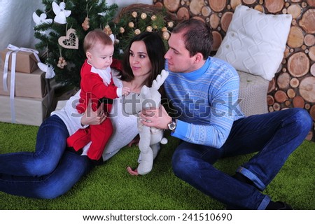 Family sitting together near fireplace in Christmas interior. Happy family having fun with Christmas presents. Christmas Family Portrait, Mother, Father And Son Celebrate Holiday, Opening Gift Box