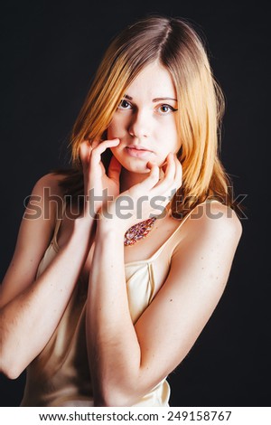 Sexy blonde Fashion Lady with messy hair in pastel beige dress isolated on black background. beautiful young blond girl posing on black studio background